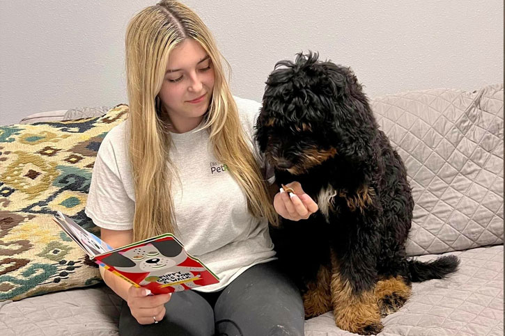 woman reading a bedtime story to a dog